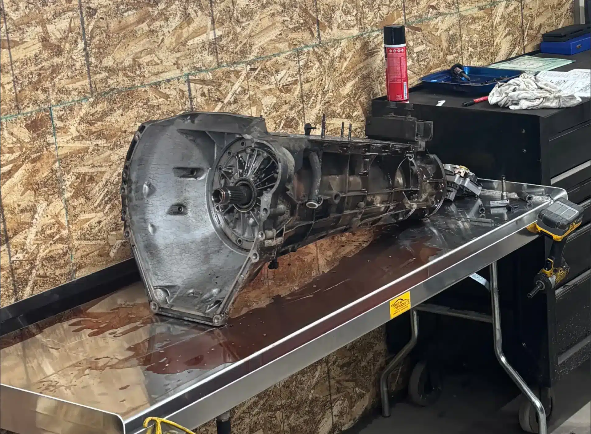 Transmission repair & replacement in Carbondale, CO by JW Diesel & Automotive. An image of a vehicle's transmission system placed on a table inside an auto repair shop.
